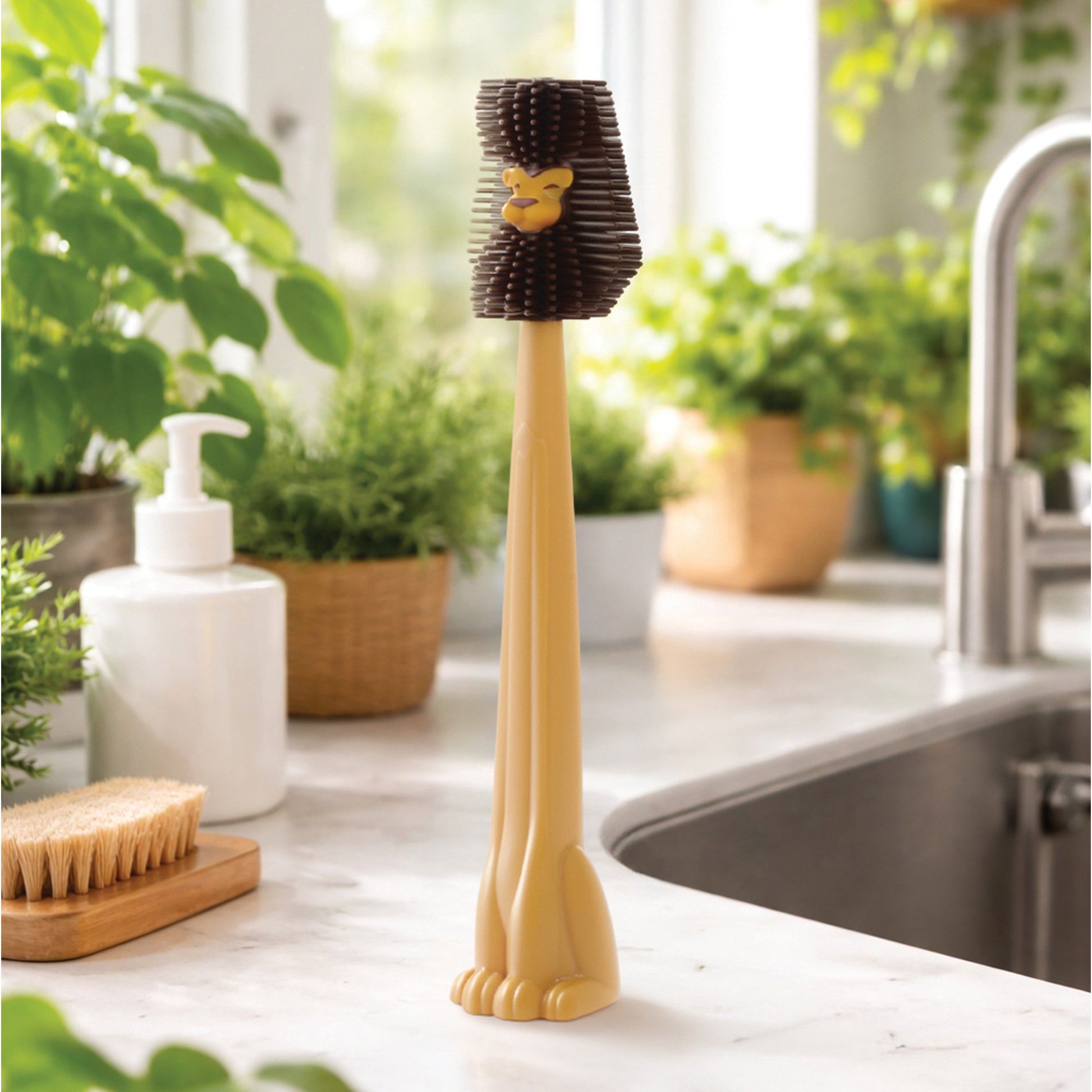 A Cleo bottle cleaner by OTOTO stands upright on the kitchen counter near the sink and plants.