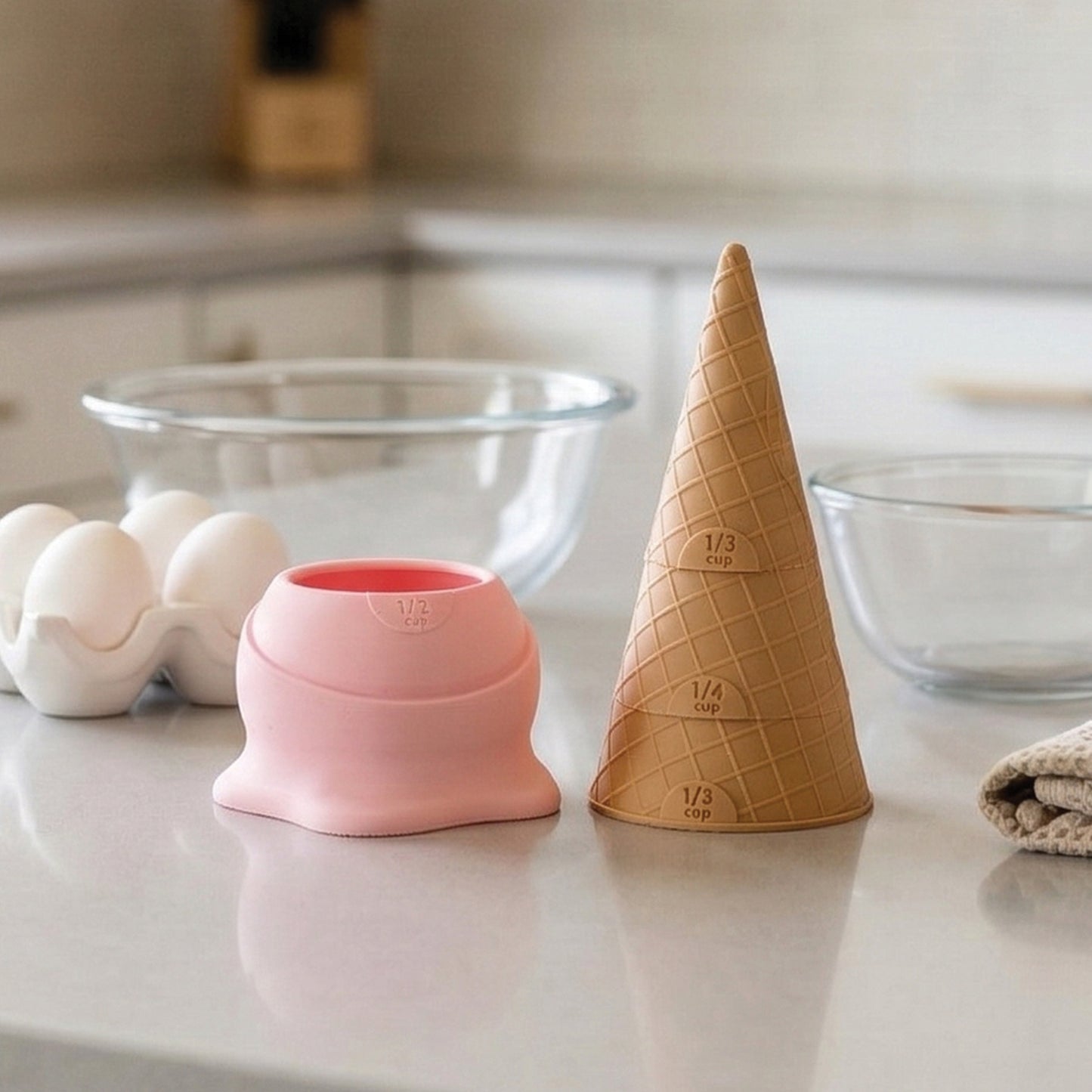 Two Coney measuring cups, ideal for baking or pancake batter, rest on a kitchen counter.