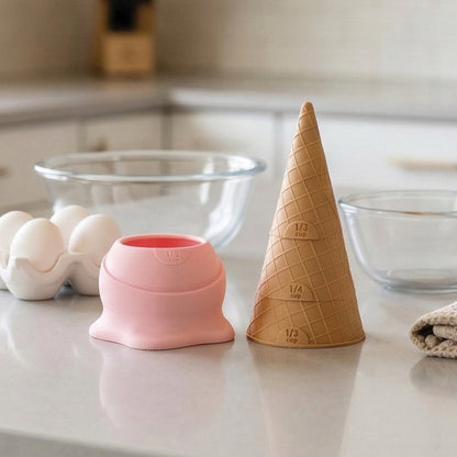 Two Coney measuring cups, ideal for baking or pancake batter, rest on a kitchen counter.