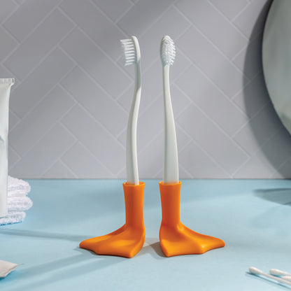 Two Duck-Clean holders by OTOTO sit on a blue counter, each with a quirky, duck-shaped base.