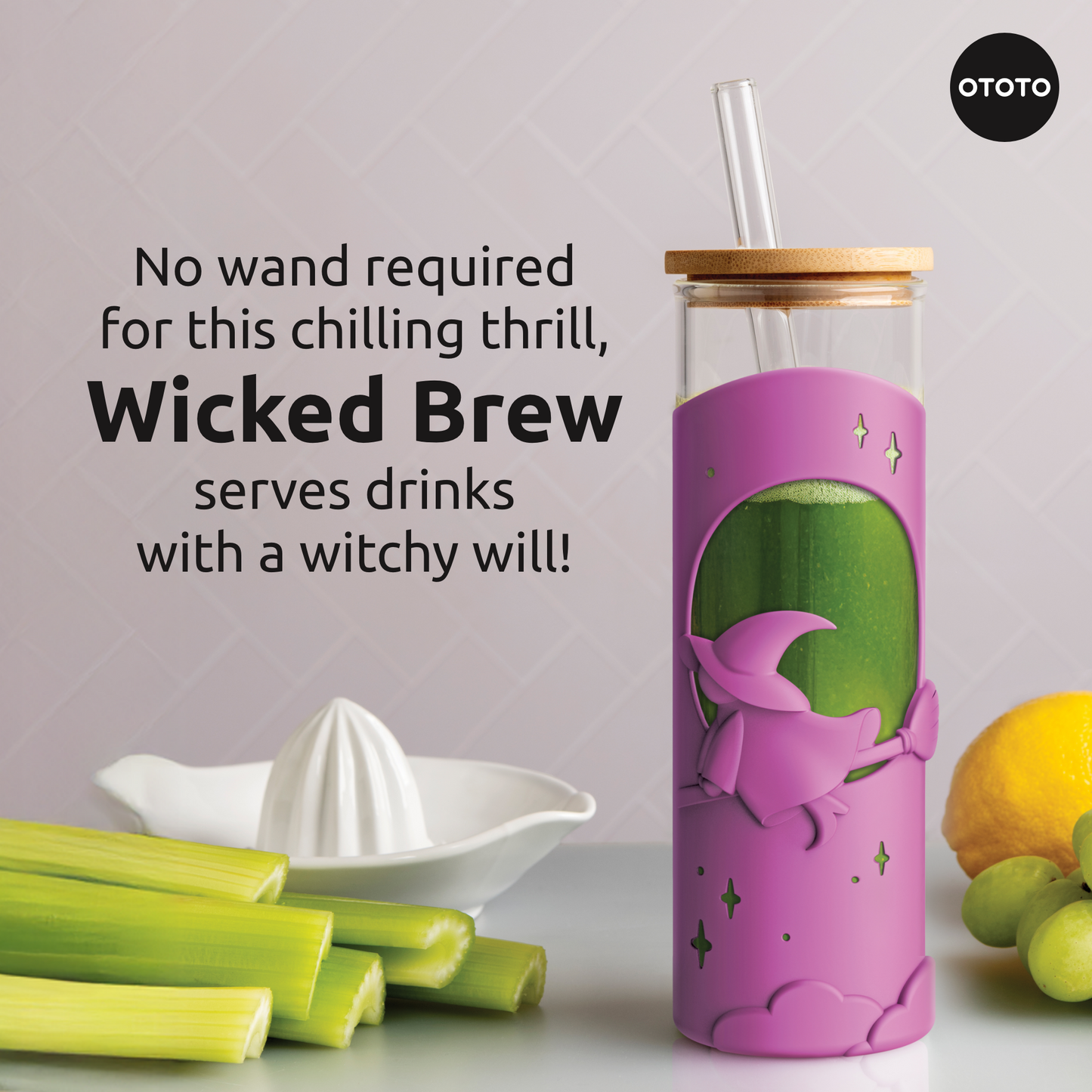 A pink OTOTO Wicked Brew witch tumbler with straw sits by celery, lemon, and a juicer.