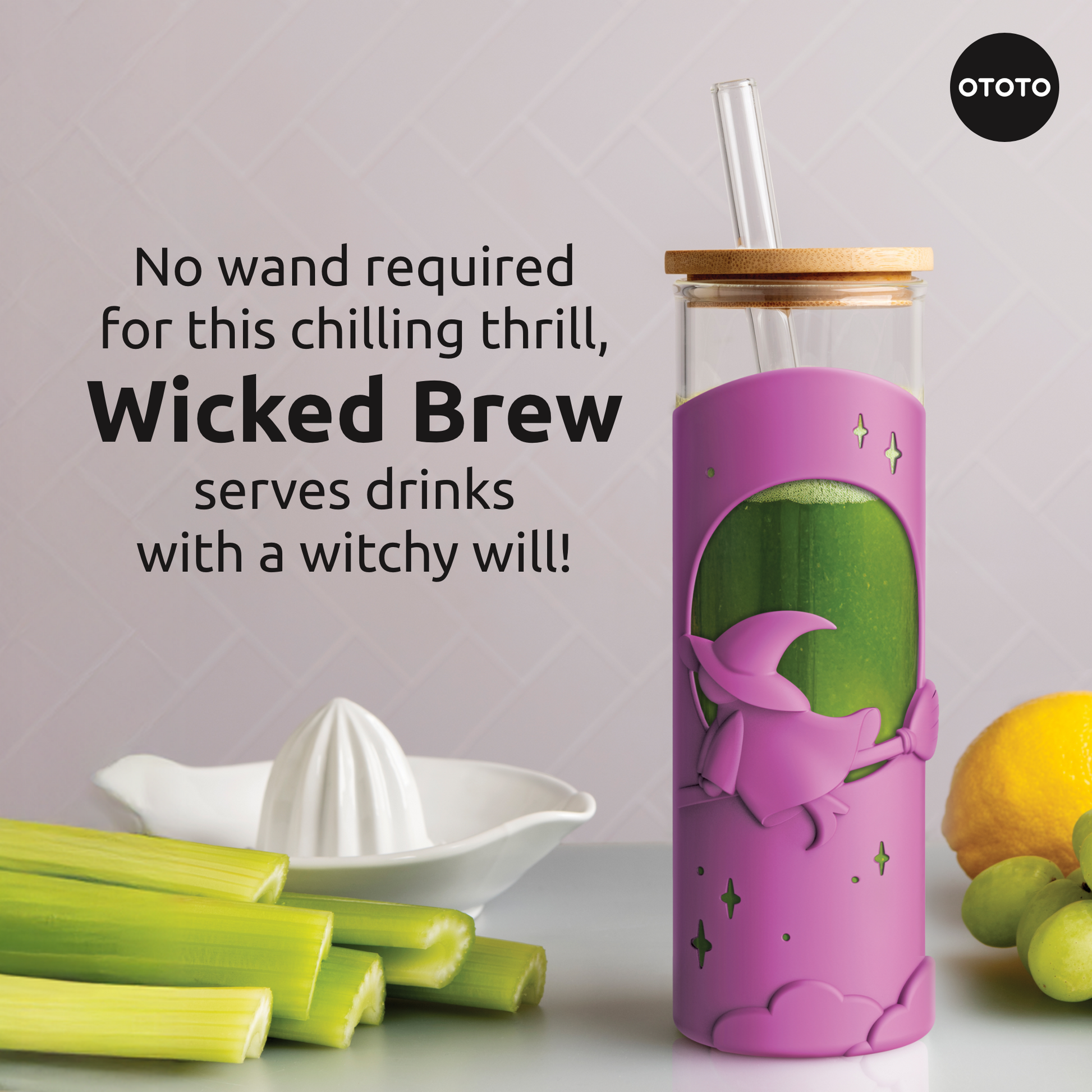 A pink OTOTO Wicked Brew witch tumbler with straw sits by celery, lemon, and a juicer.