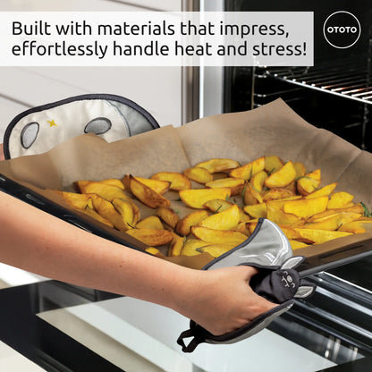 Hands with cute, gray Batlicious oven mitts remove a tray of potato wedges from the oven.