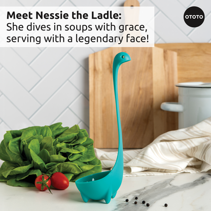 A blue Prep Pals ladle stands upright among veggies and kitchen tools on the counter.