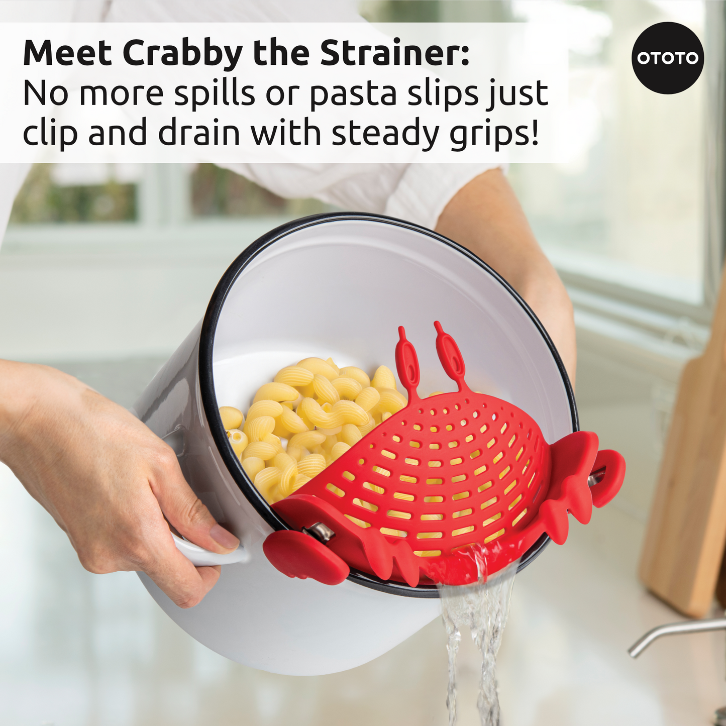 Hands draining pasta with the Prep Pals crab strainer over the kitchen sink.