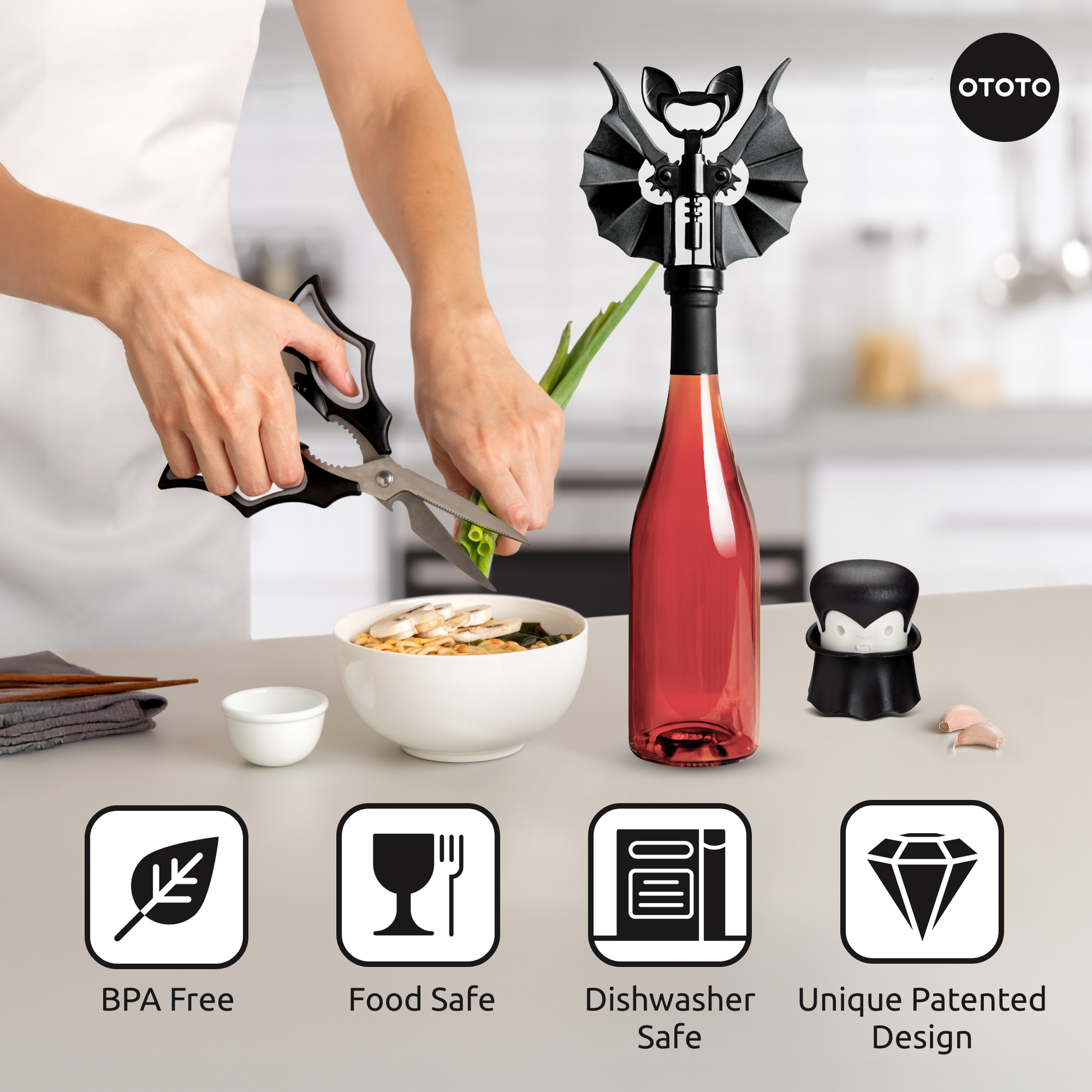 Person uses Boo-tiful Crew bat-shaped shears; vampire kitchen tools and opener complete the scene.