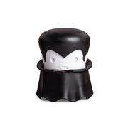 A cartoon vampire with a cape and fangs holds an OTOTO Gracula garlic crusher.