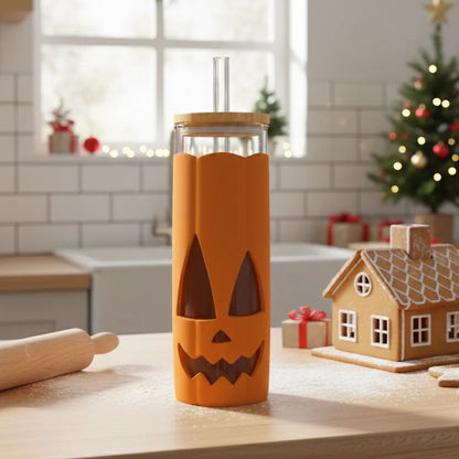 A Jack-o-Cup glass tumbler with a pumpkin spice vibe sits by festive decor on the kitchen counter.