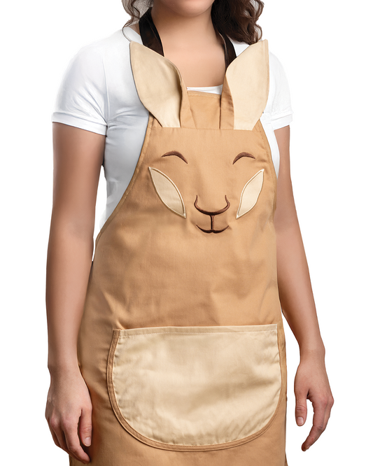 A woman wears the Aproo tan kitchen apron featuring a cute bunny face, ears, and a big front pocket.