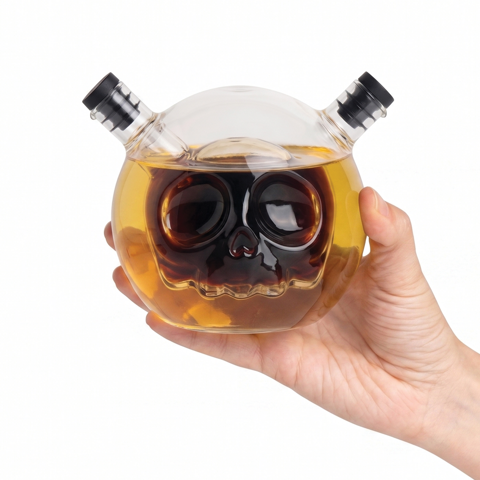 A hand holds a Skully-Olio, an OTOTO skull-shaped oil and vinegar dispenser with two spouts.
