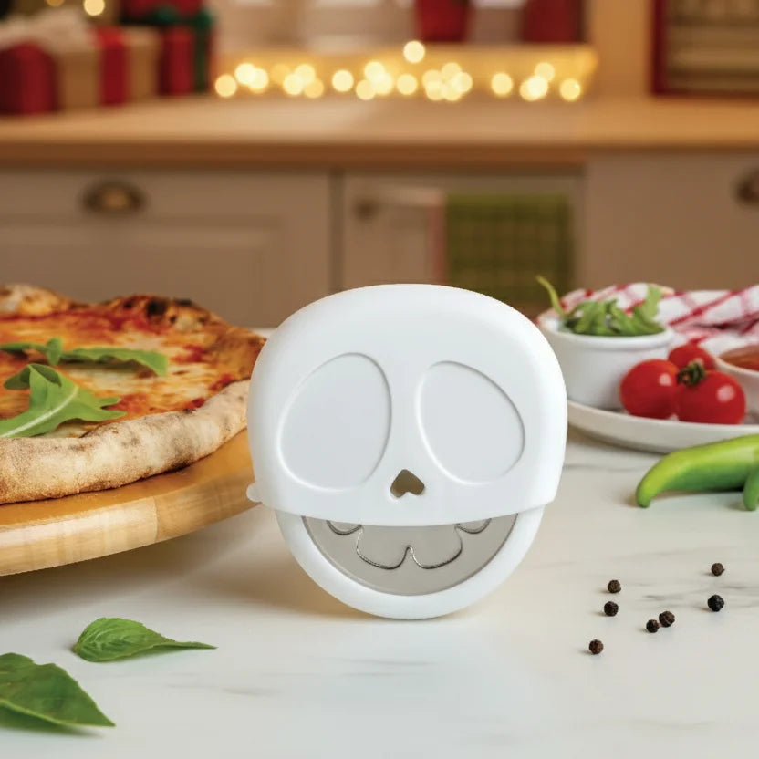 The Slice Reaper pizza cutter by OTOTO stands on a kitchen counter beside a pizza and fresh toppings.