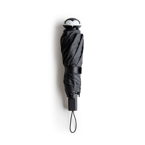 Stylish Spookula umbrella by OTOTO, features a penguin handle and wrist strap, on a white background.