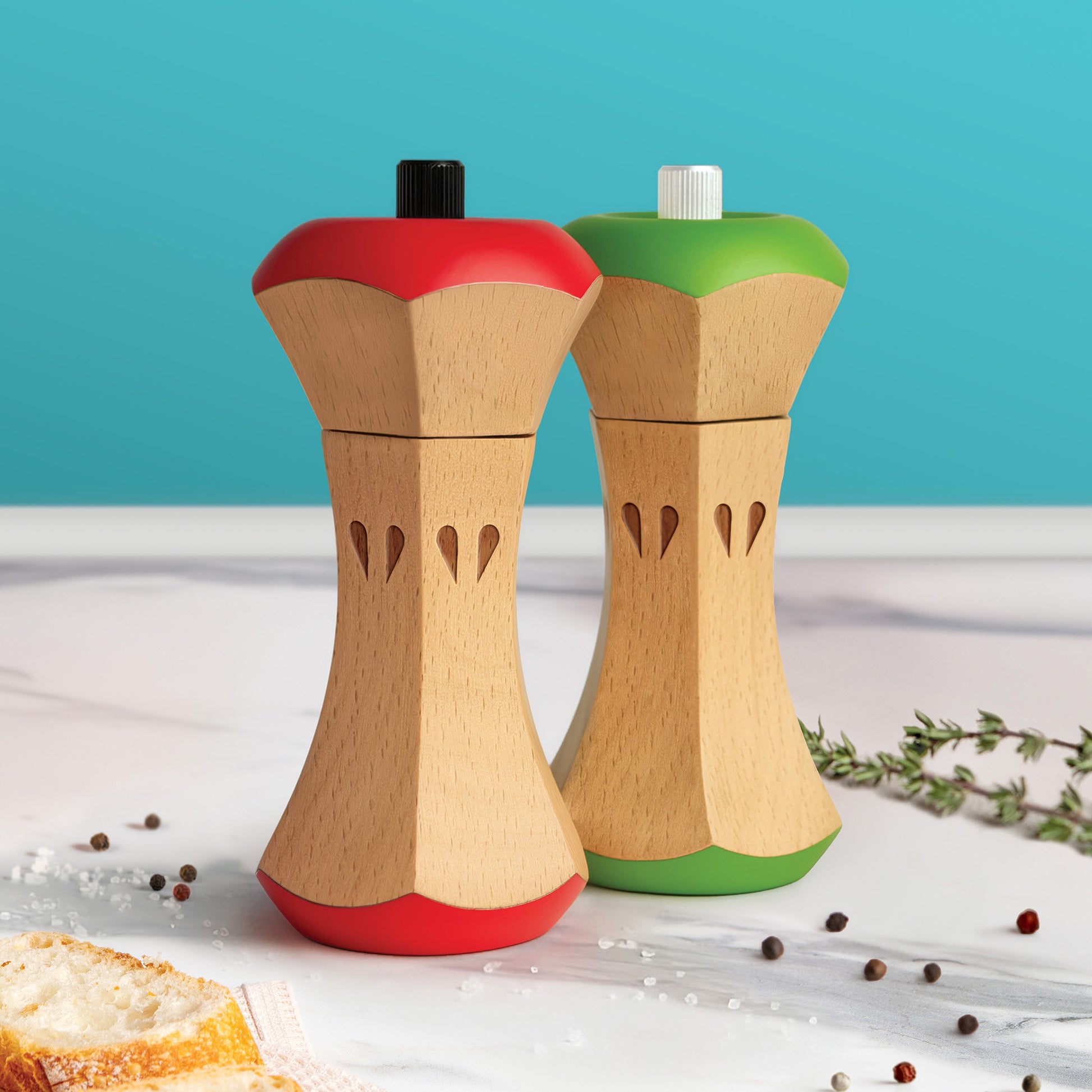 Twin Spice: two apple-shaped wooden grinders with red and green tops, perfect for any kitchen.