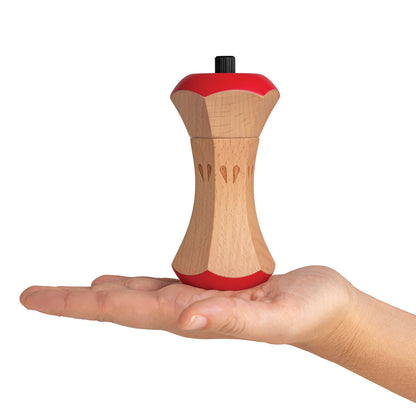 A hand holds the Twin Spice wooden manual grinder with red accents, for salt and pepper.
