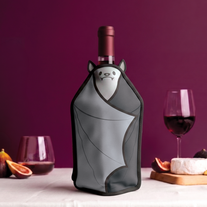 Wine bottle with an OTOTO Vino bat-shaped wine cooler on a table with glasses, cheese, and figs.