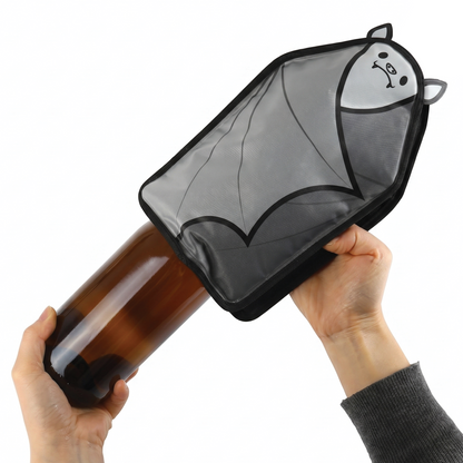 A person puts the OTOTO Vino bat-shaped wine cooler sleeve onto a brown glass bottle.
