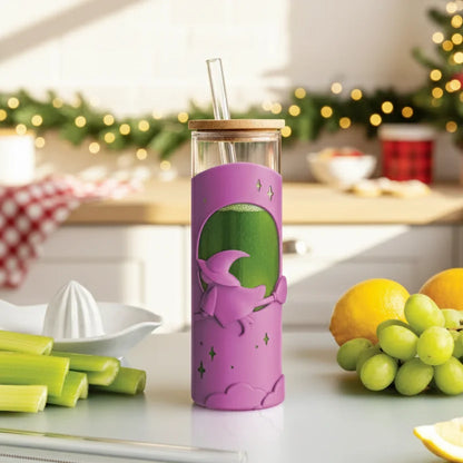 Wicked Brew: green juice served in a purple boba cup with a witch design, fruit on the counter.