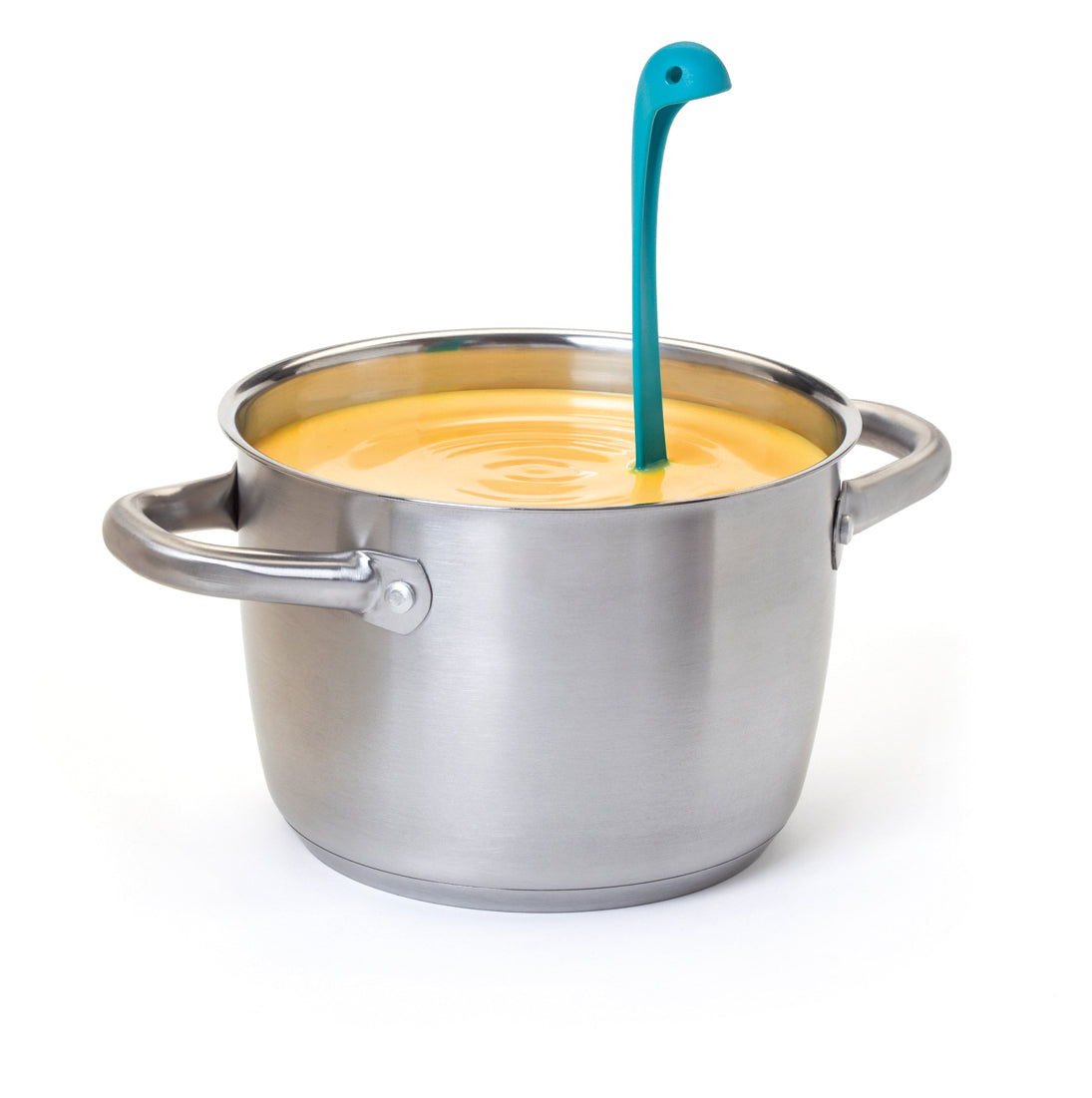 Nessie, a blue dinosaur-shaped OTOTO soup ladle, stands in a pot of yellow soup on white background.