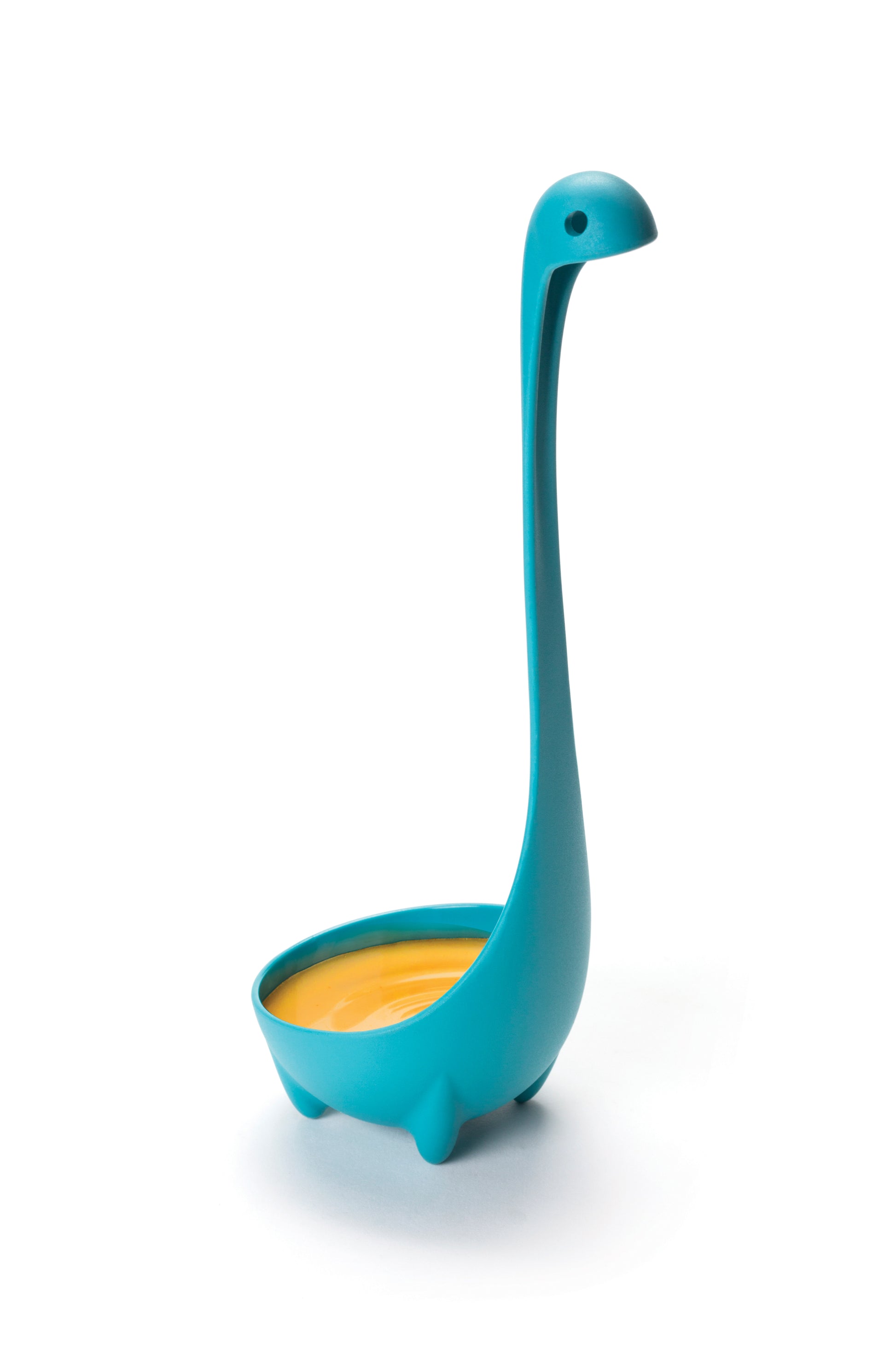 Nessie, OTOTO's blue dinosaur ladle, stands upright filled with soup on a white background.