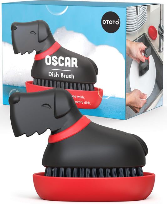 Oscar Dish Brush by OTOTO, dog-shaped with black bristles and red base, shown in use.